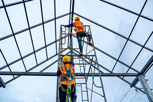 Worker on scaffolding carrying out a task at height on a construction site